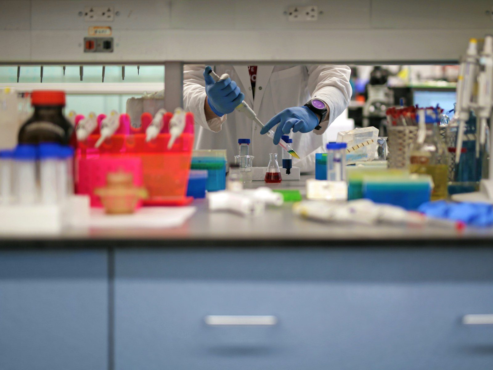 Gloved hands handling samples in a laboratory